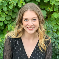 Image of student, Tatum McKay, smiling in front of floral background