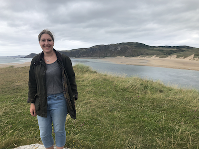 woman stands on a beach in Ireland