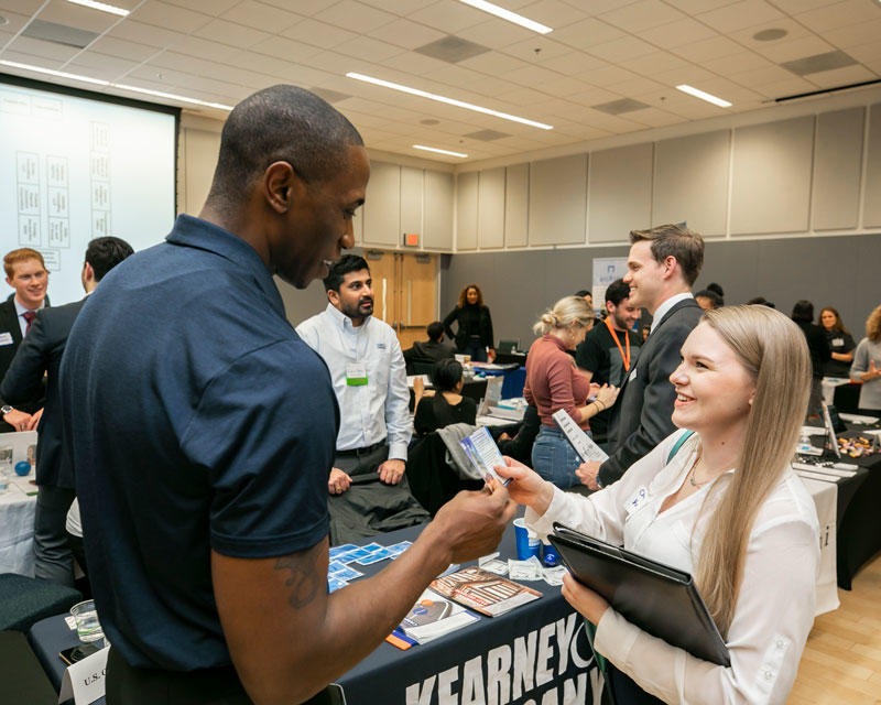 People exchange information at a graduate career fair held at the Arlington Virginia campus of George Mason University